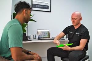 UFIT Podiatrist Consults Client while holding insoles